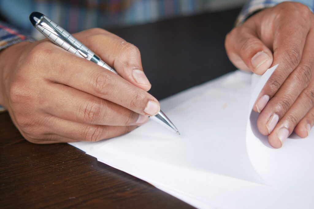 man hand in fountain pen writing or signature on paper .